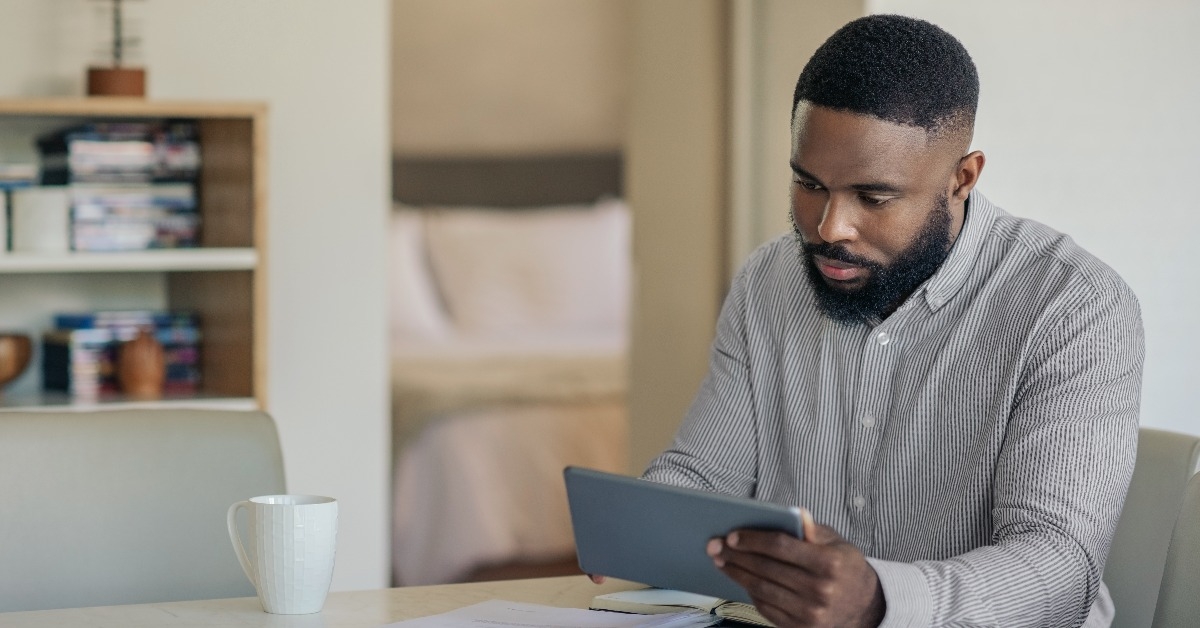 African American man doing his online banking with a tablet