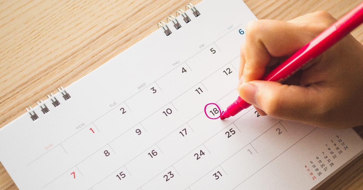female hand with pen mark on calendar date