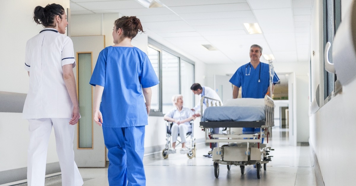 male nurse pushing stretcher gurney bed in hospital corridor