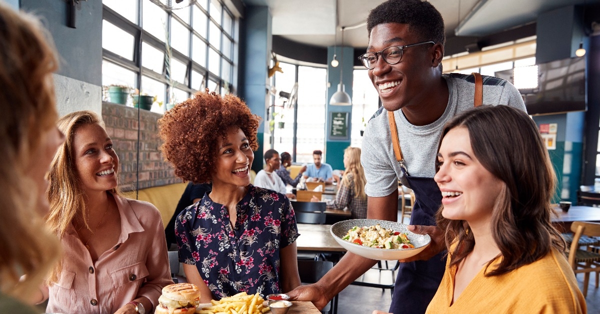 waiter serving group of female friends