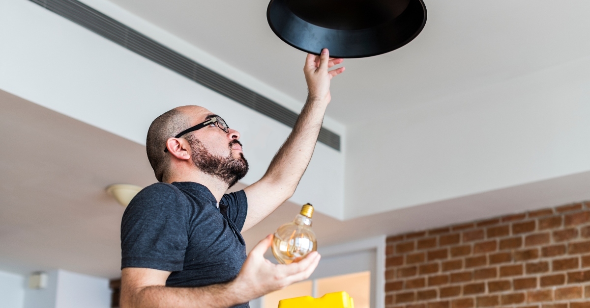 man changing light bulb