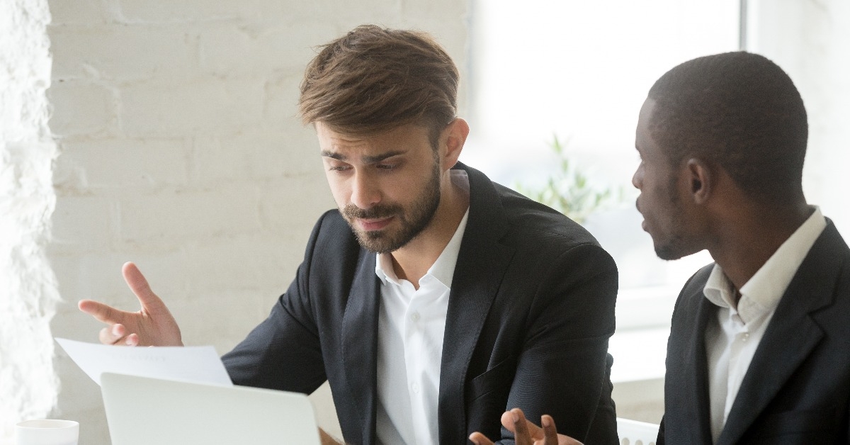 multi-ethnic colleagues having claims fight about mistake in business document