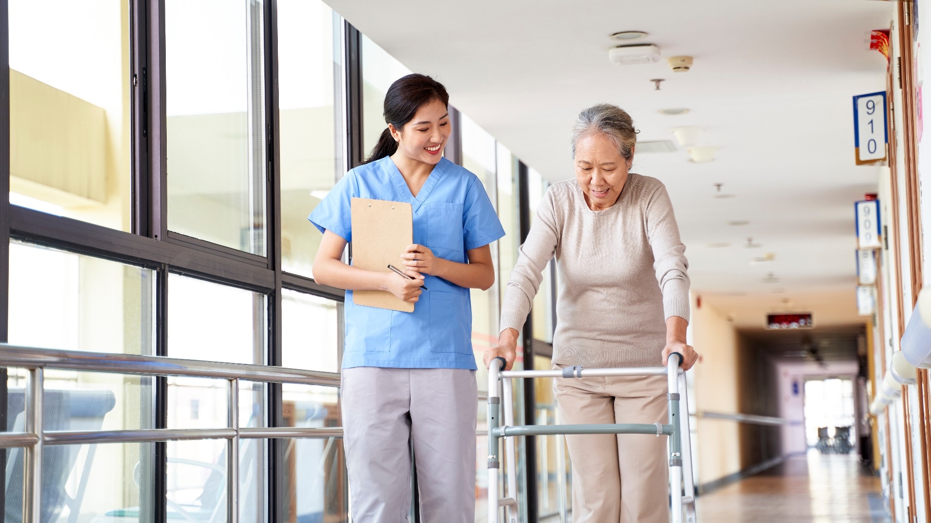 asian old woman walking with a walker in rehab center