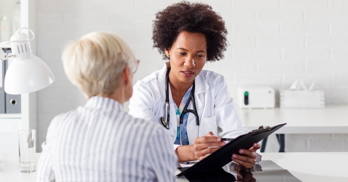 mature woman with her doctor in ambulance talking about healthcare