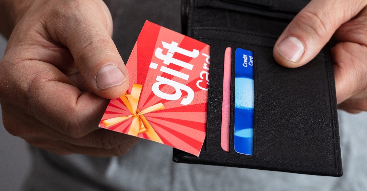 human hand removing gift card from wallet