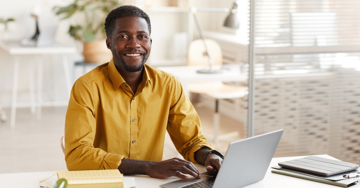 smiling African-American man using laptop