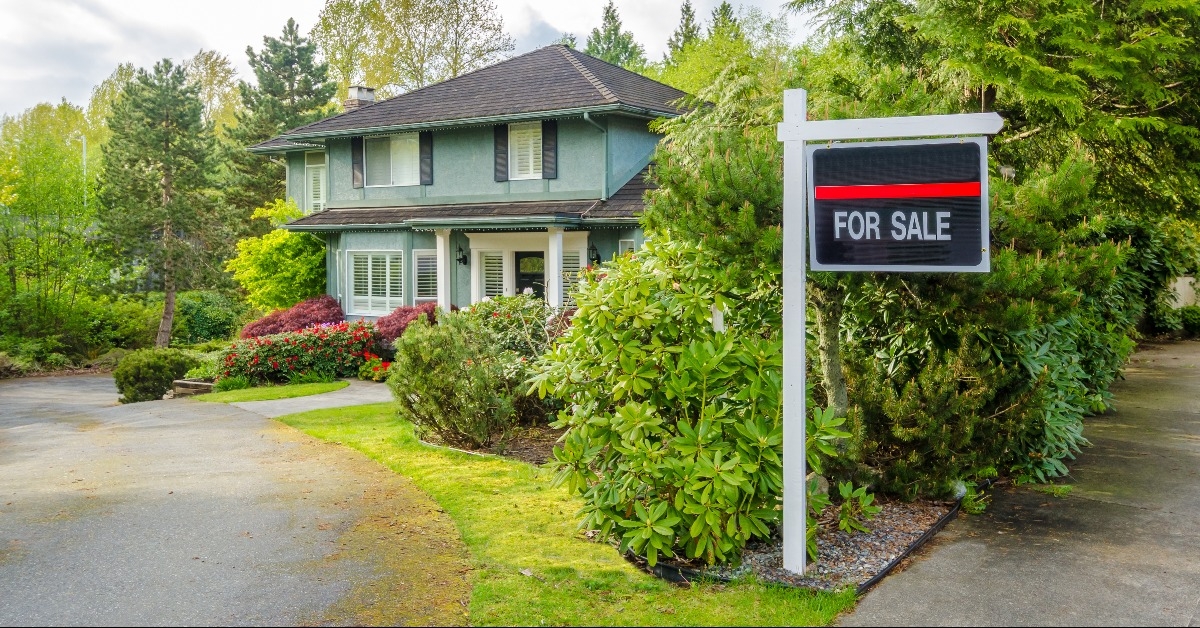 house for sale real estate sign in front of a house