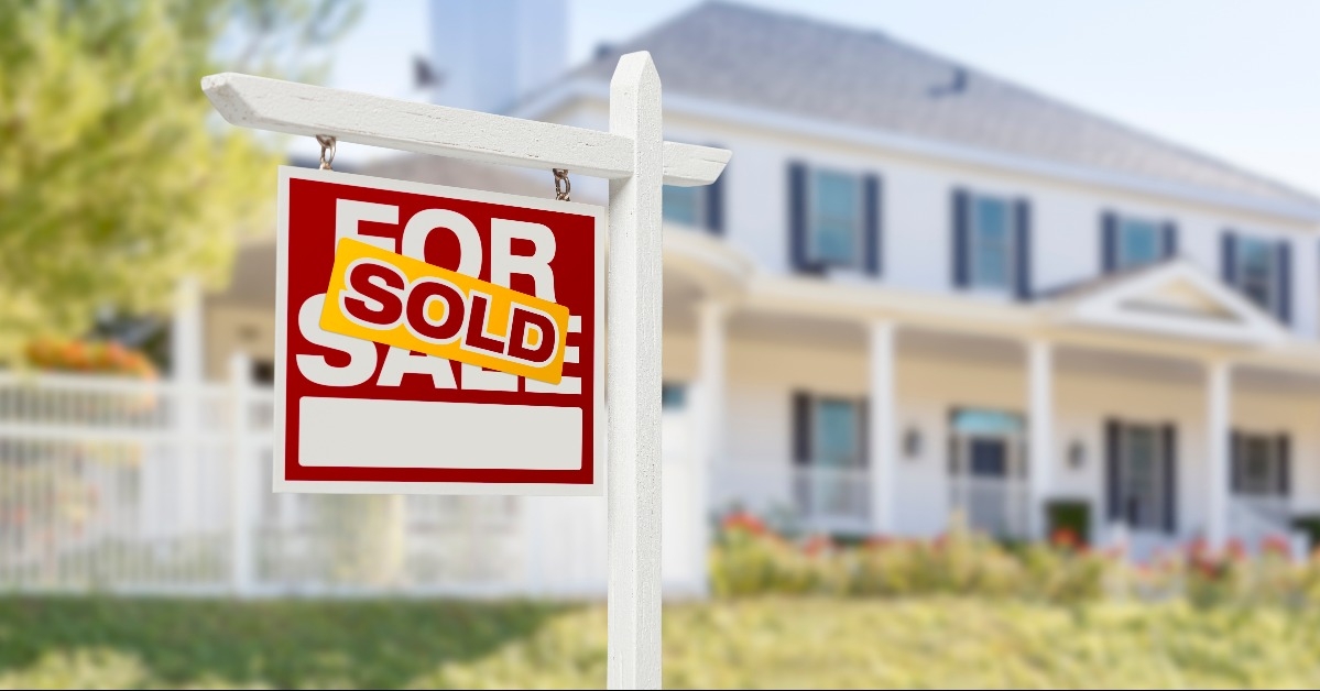 sold home for sale sign in front of new house