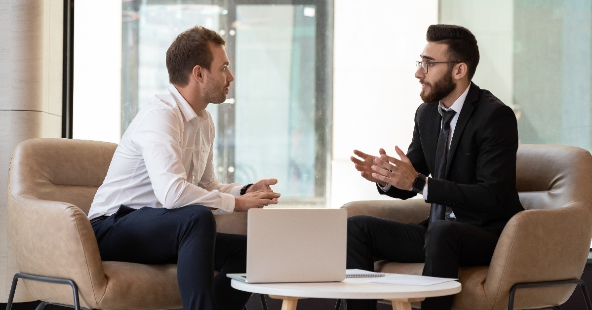  businessmen talking negotiating indoors