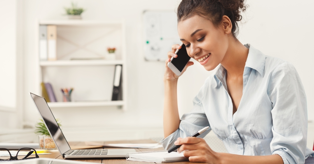 Smiling business woman at work talking on phone