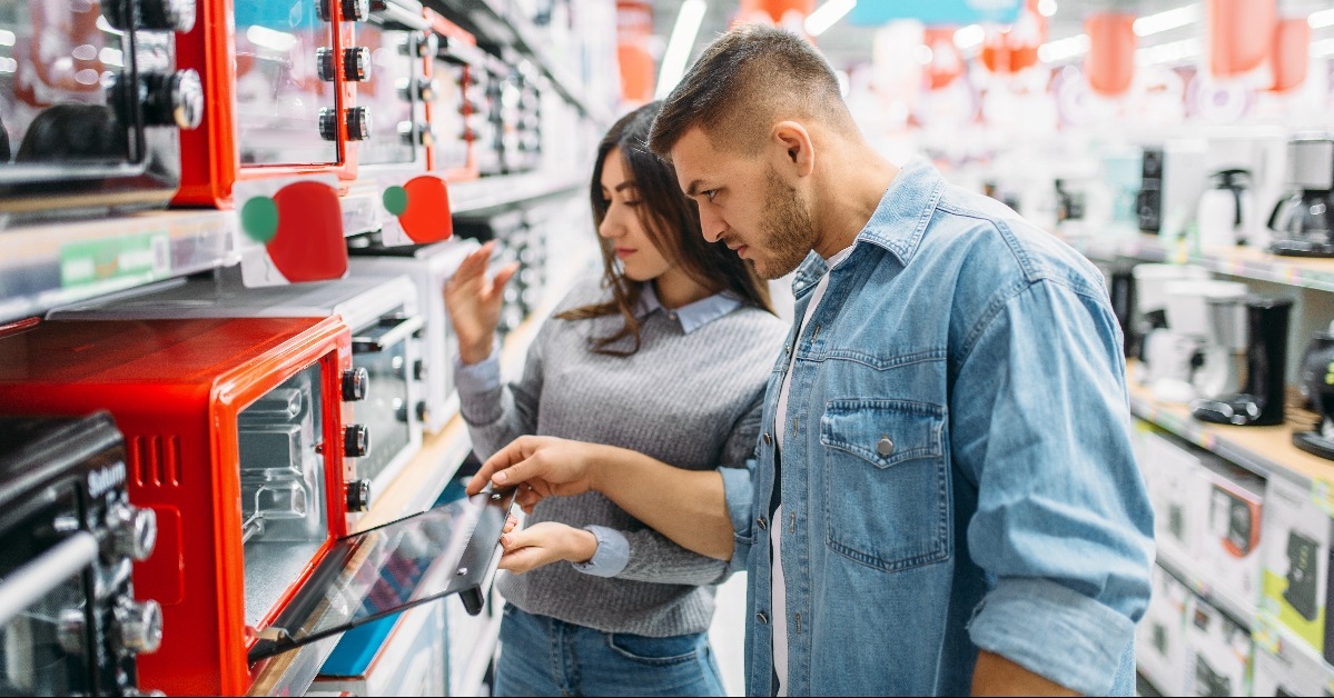 couple buys an electric oven in a supermarket