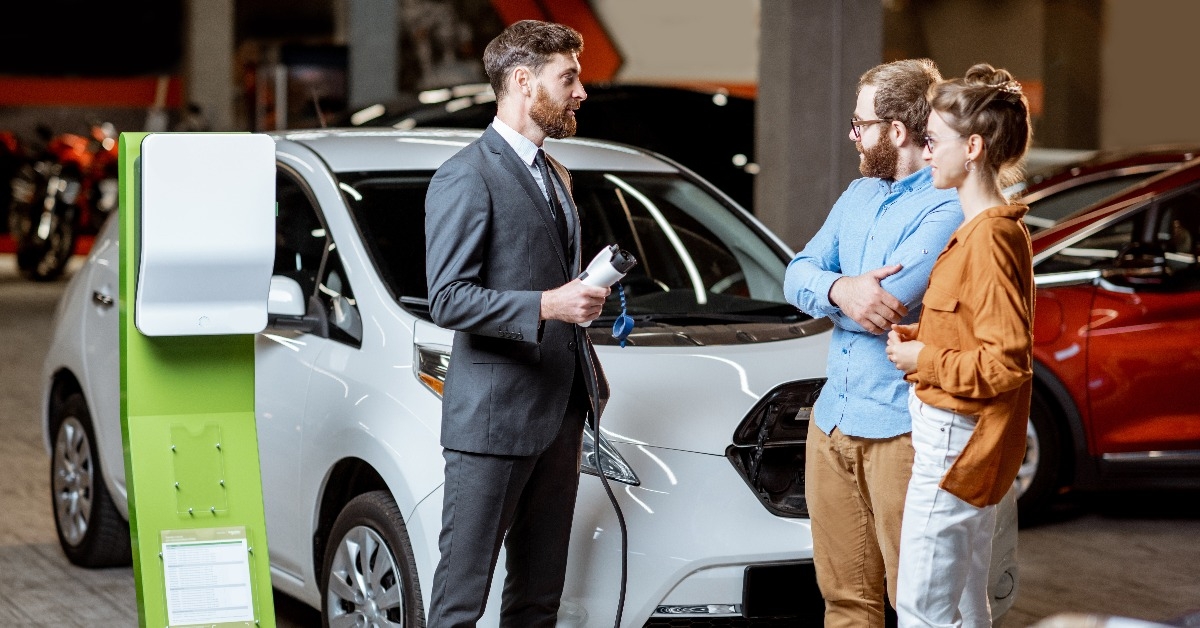 sales manager selling electric car to a young couple