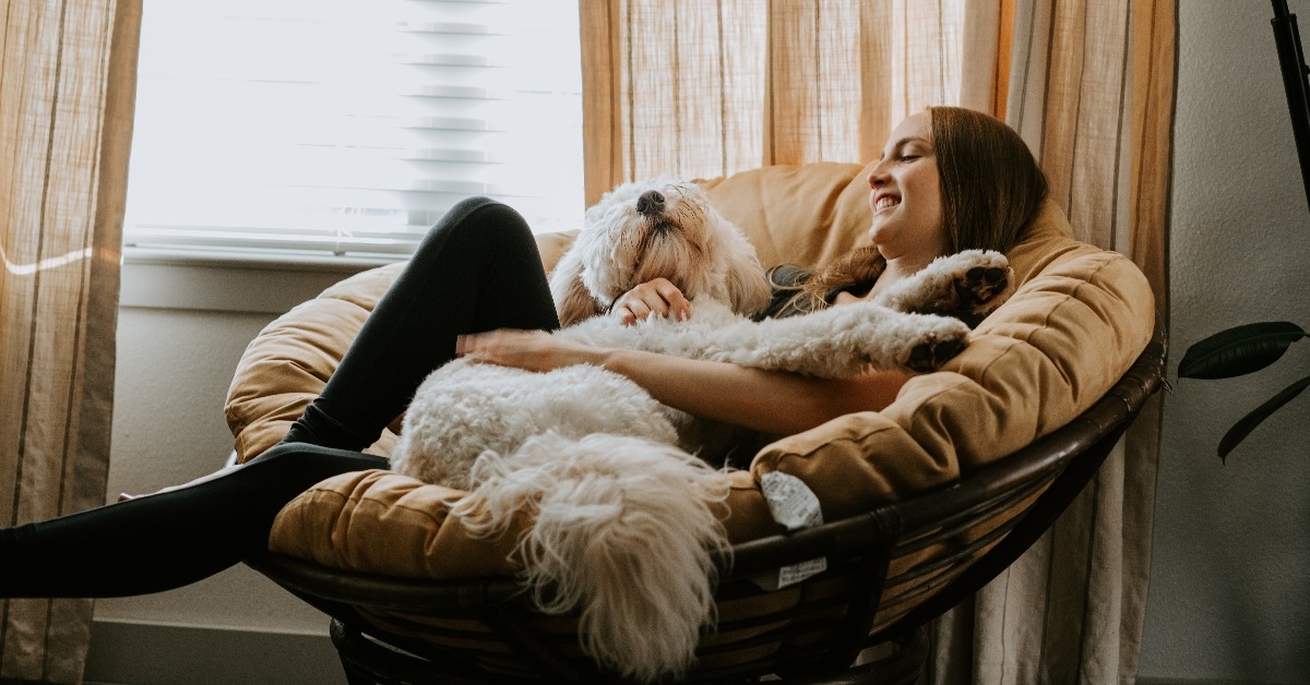girl holding her dog on comfy chair