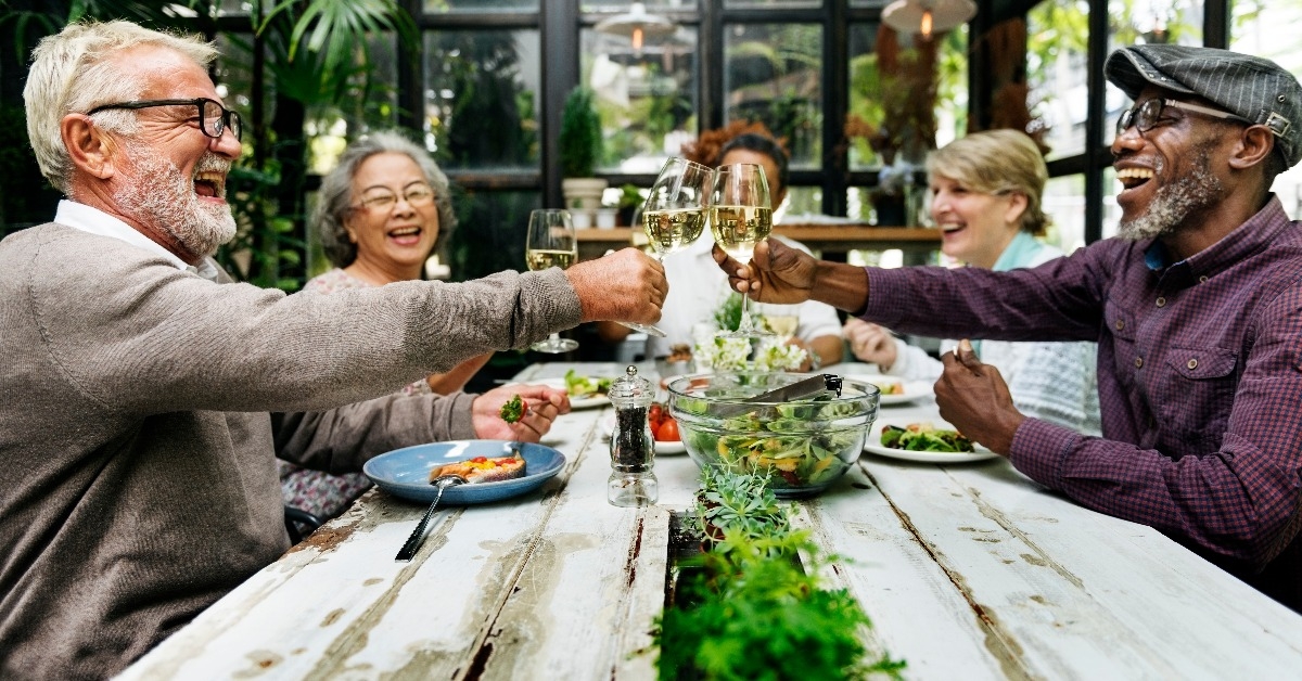 group of senior friends dining happily