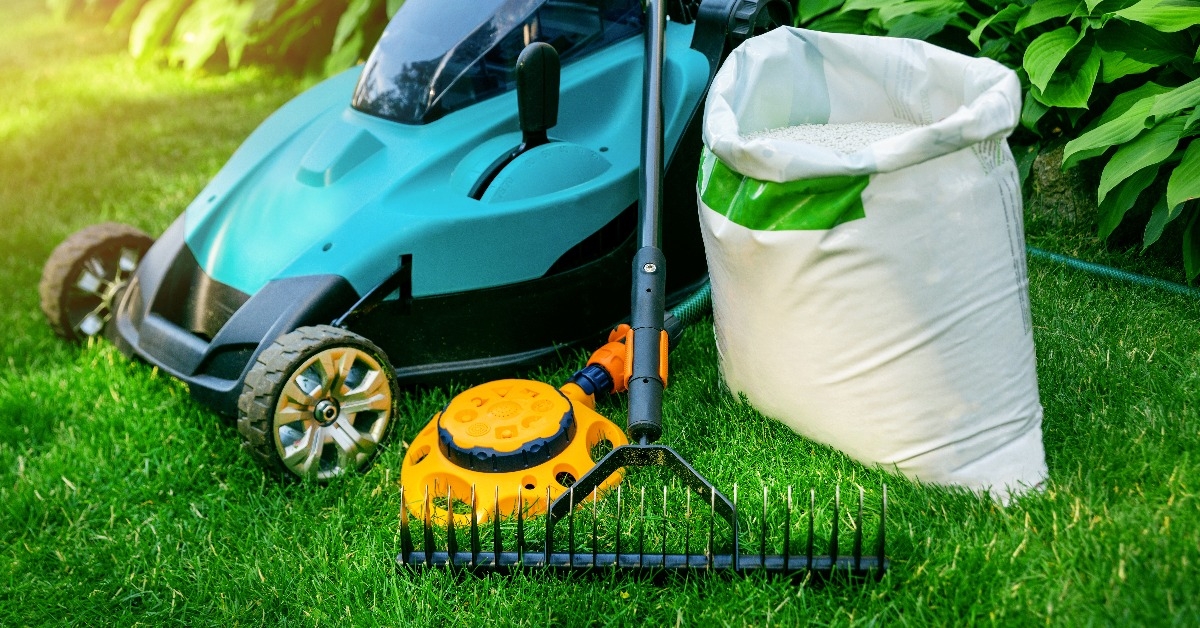 gardening tools and lawn care equipment on green grass