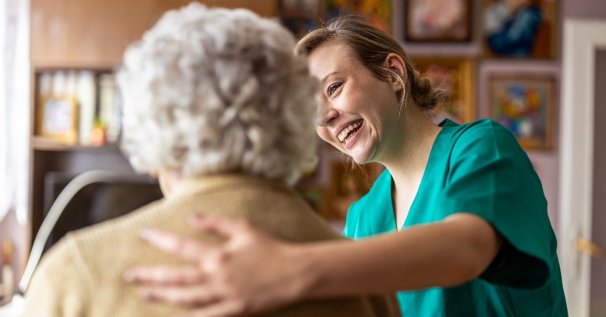 Friendly nurse supporting an elderly lady