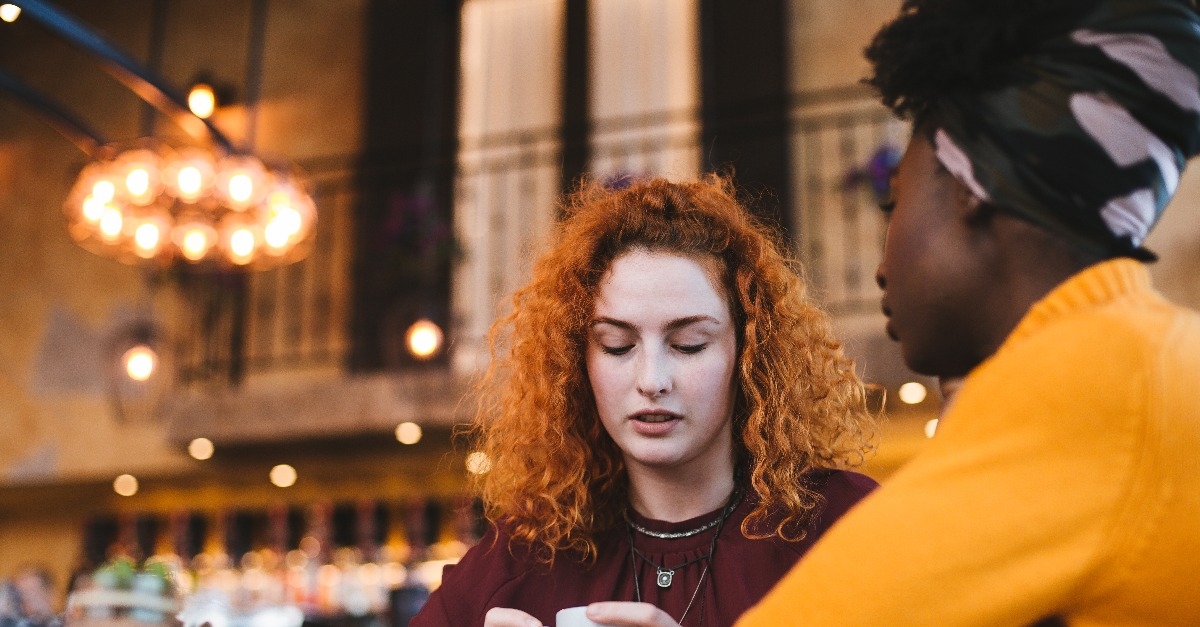  young woman is talking with a female friend about her problem in a cafe