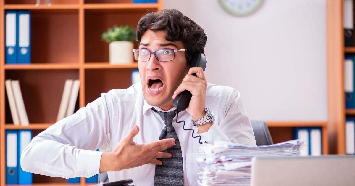 Young handsome businessman unhappy with excessive work