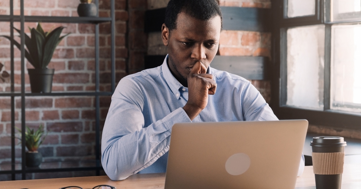 Man looking at computer and thinking