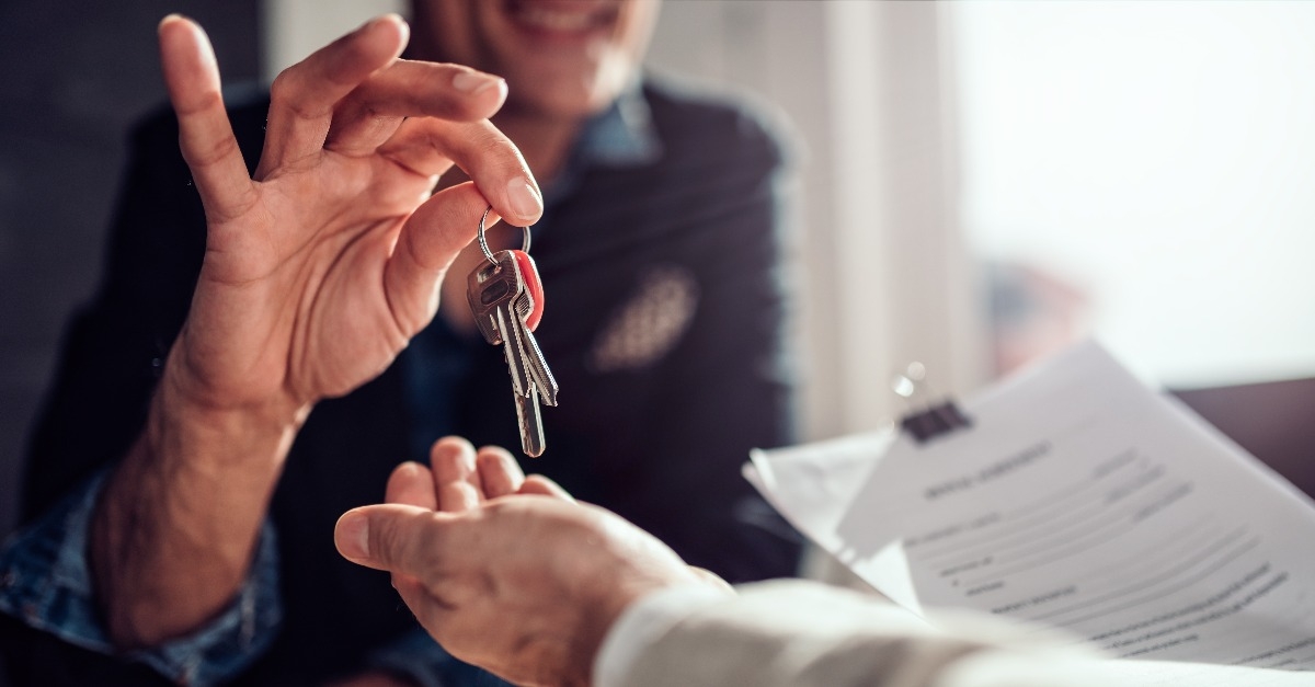 Real estate agent passing keys to his client