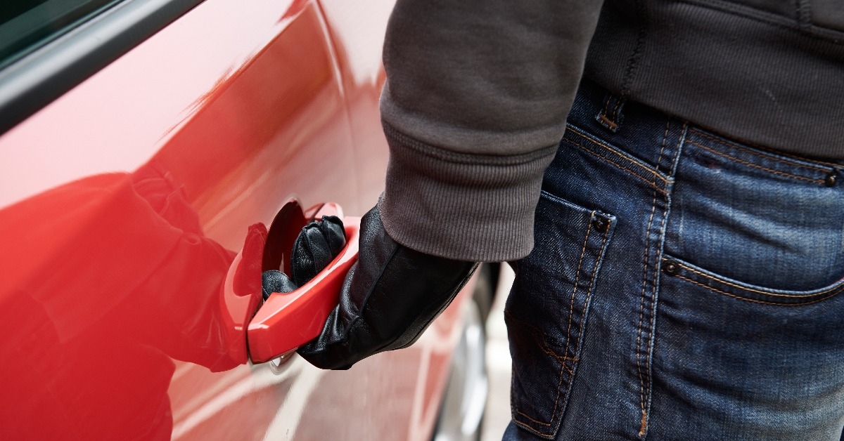 car thief trying door handle to see if vehicle is unlocked