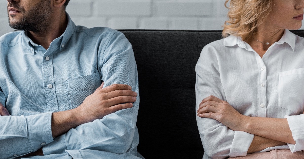 couple sitting on couch after quarrel