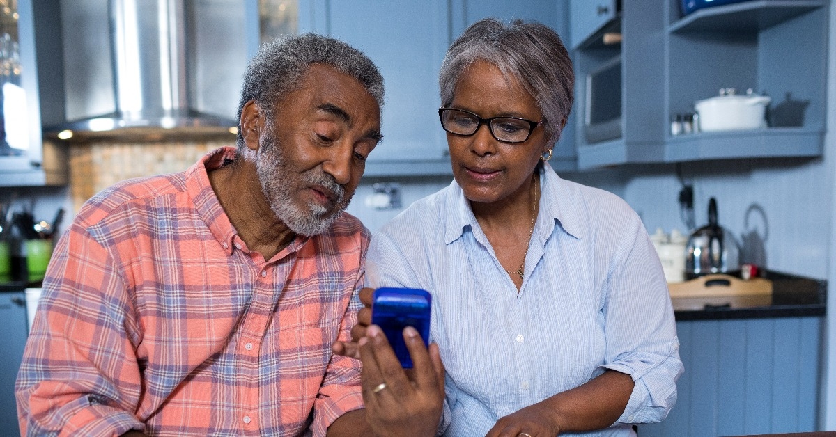 Couple using calculator in kitchen