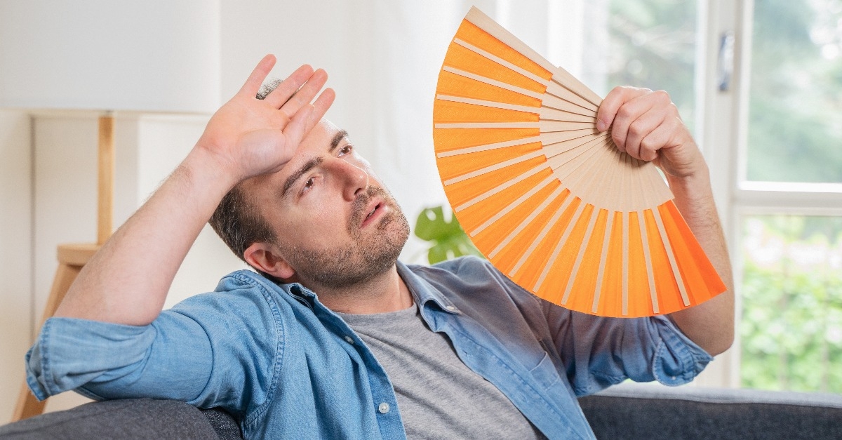 One man sweating suffering summer heatwave at home