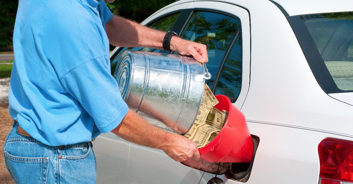 pouring money into gas tank