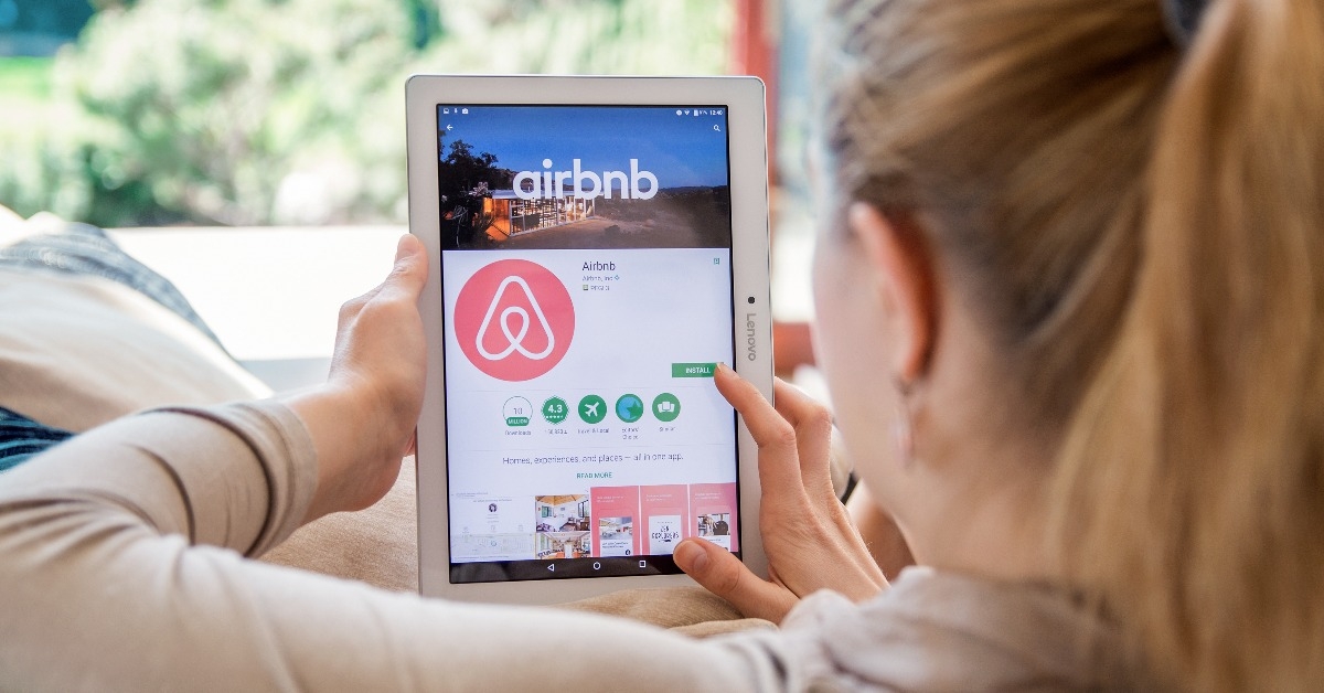 Woman is installing Airbnb application on Lenovo tablet