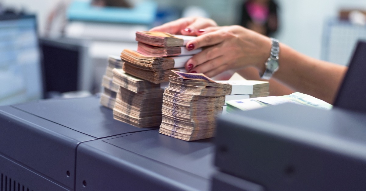 Bank employees sorting and counting money inside bank vault