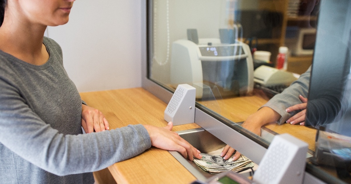 clerk giving cash money to customer at bank office