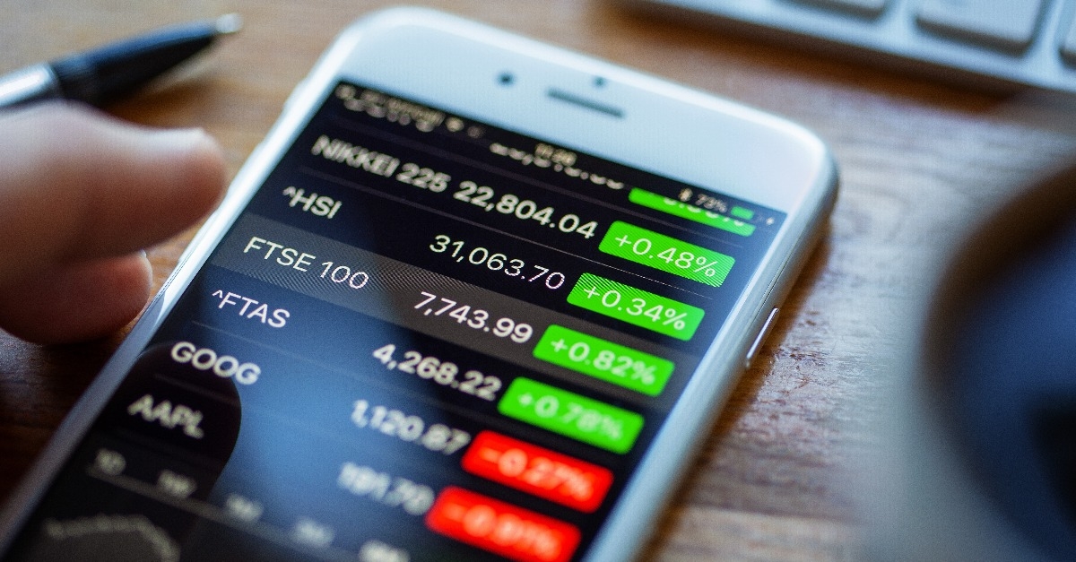 Apple iPhone 6 on a desk displaying stock market information