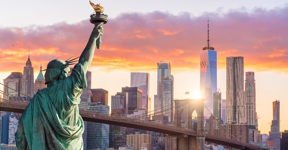 Statue of Liberty and New York city skyline at sunset