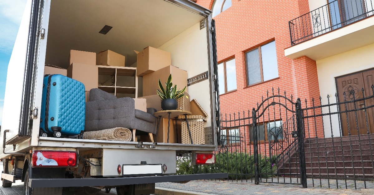 Van full of moving boxes and furniture near house