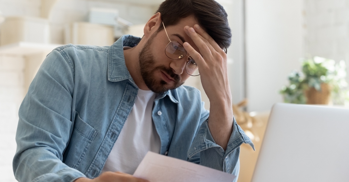 Frustrated young man reading letter