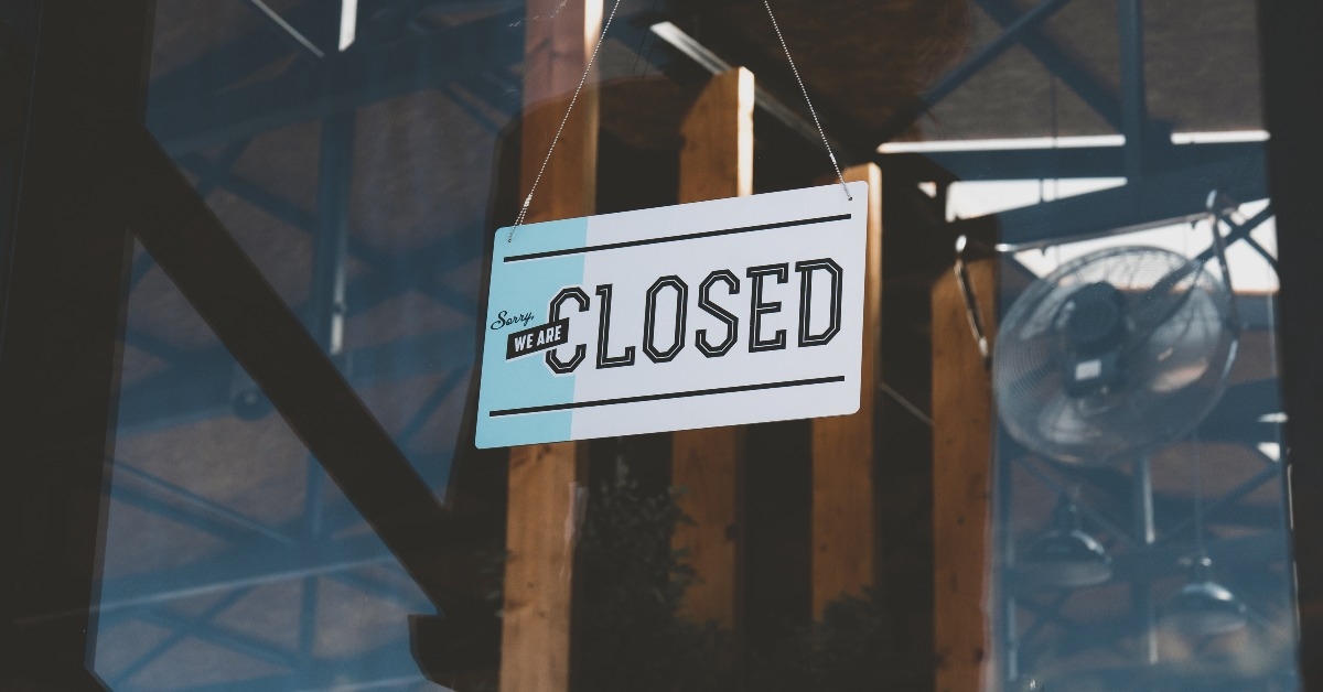 CU closed sign hanging on the entrance door of a small cafe