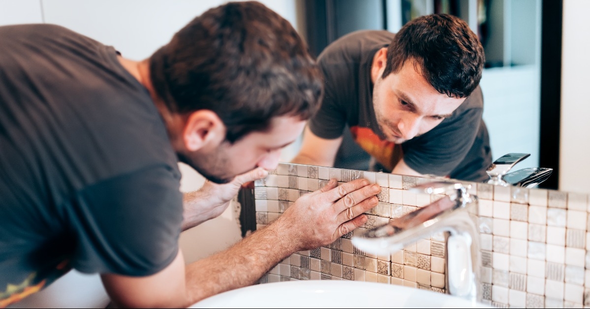 Construction details with handyman or worker adding mosaic ceramic tiles