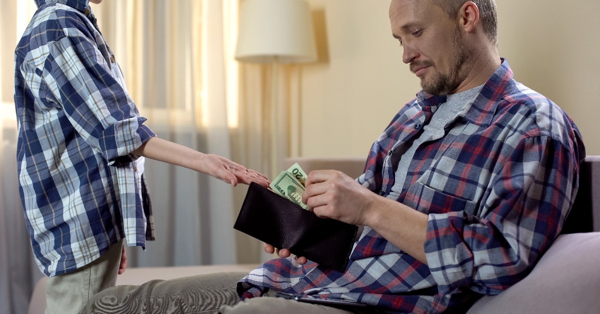 Small son asking his father for money for going to cafe with friend