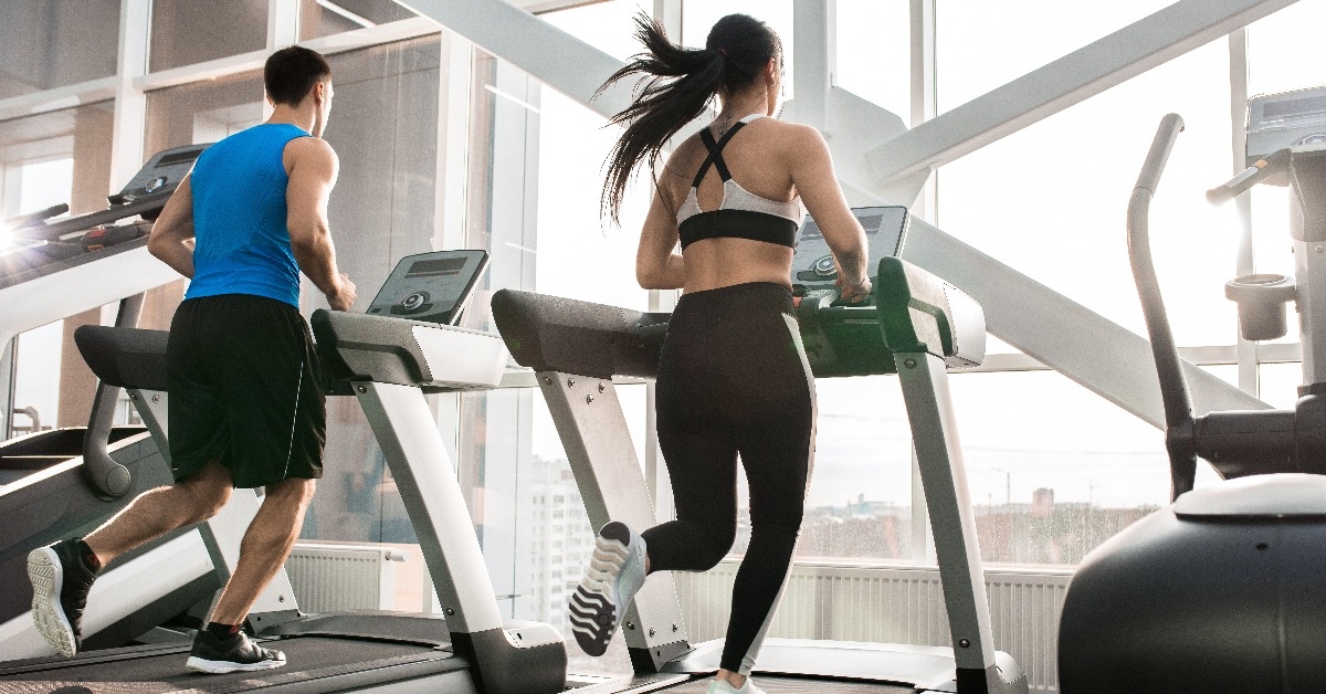 man and woman running on treadmills