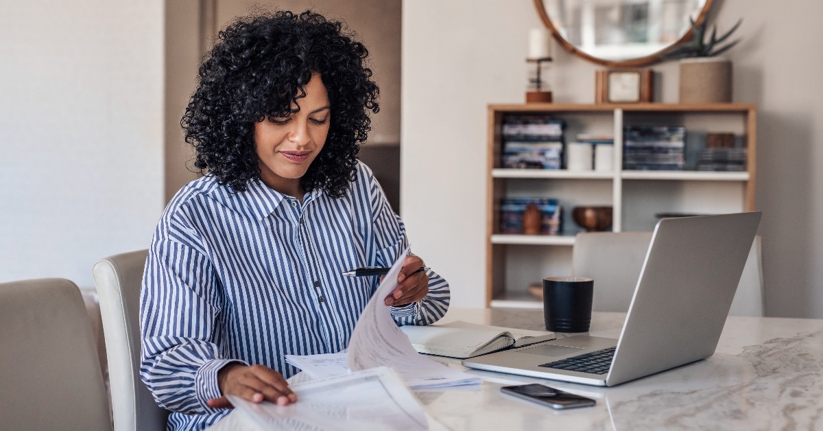 Smiling female entrepreneur going through paperwork