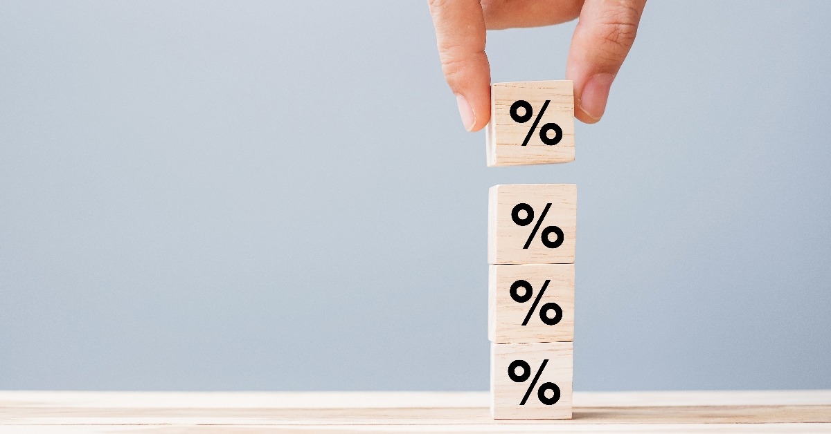 hand putting wood cube block with percentage symbol icon