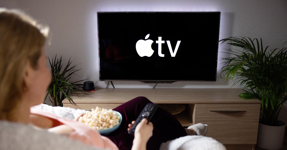  Woman watching television at home Apple TV logo on the screen