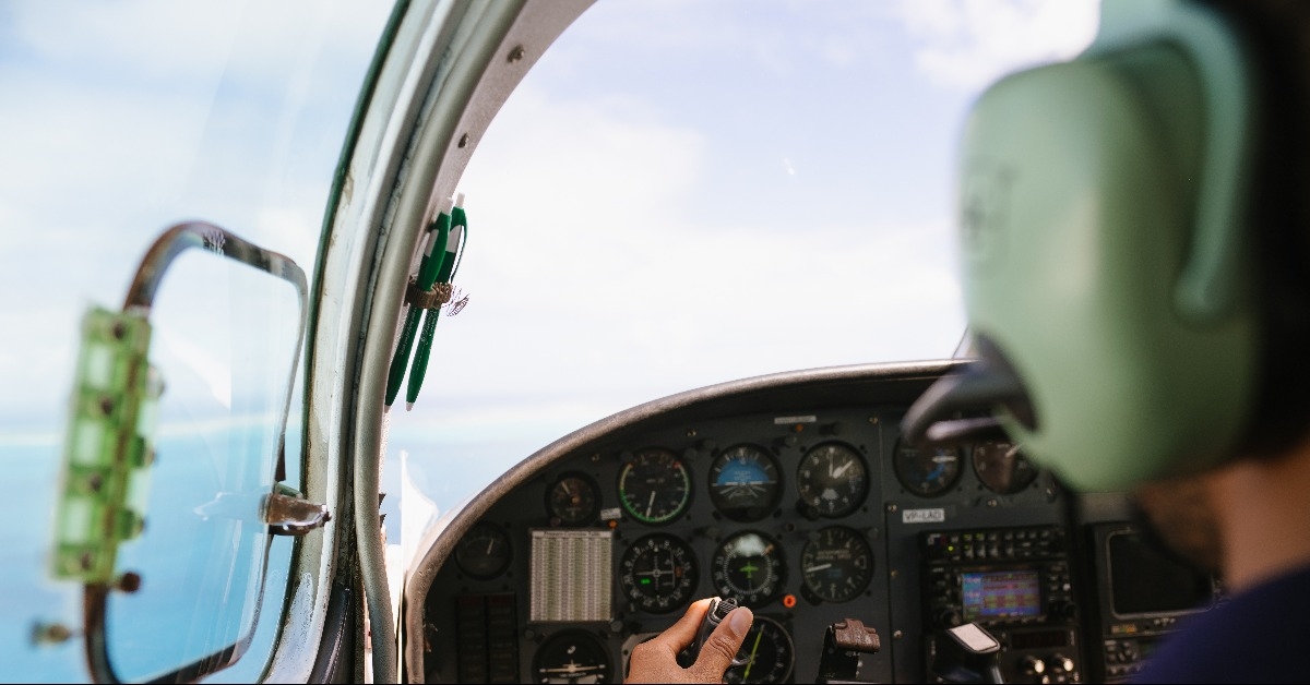 Over the shoulder of pilot flying a small plane