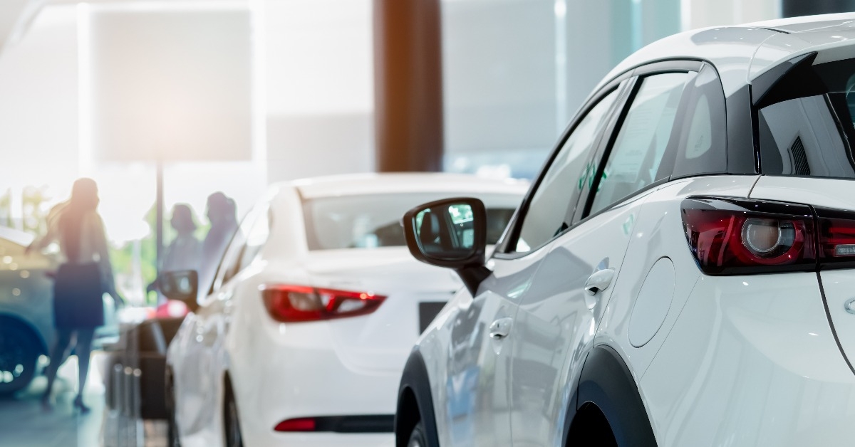 white SUV car in modern luxury showroom on blur saleswoman