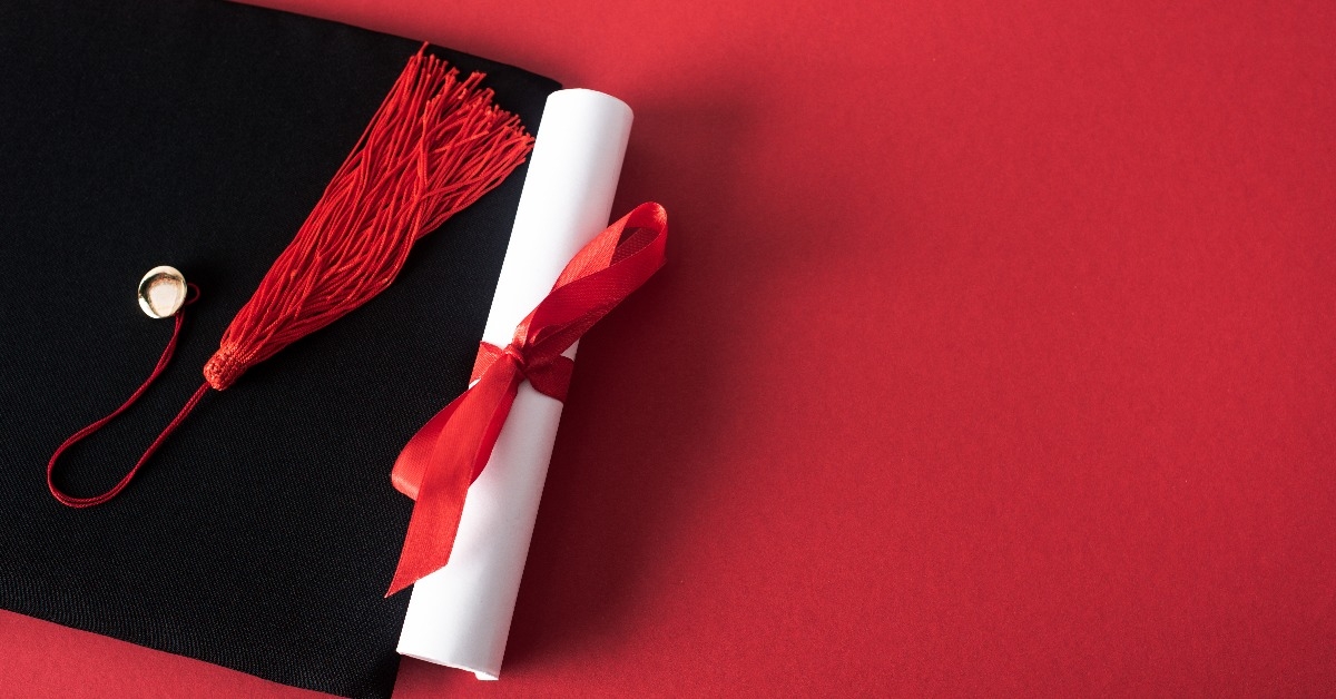 diploma with beautiful bow and graduation cap with tassel