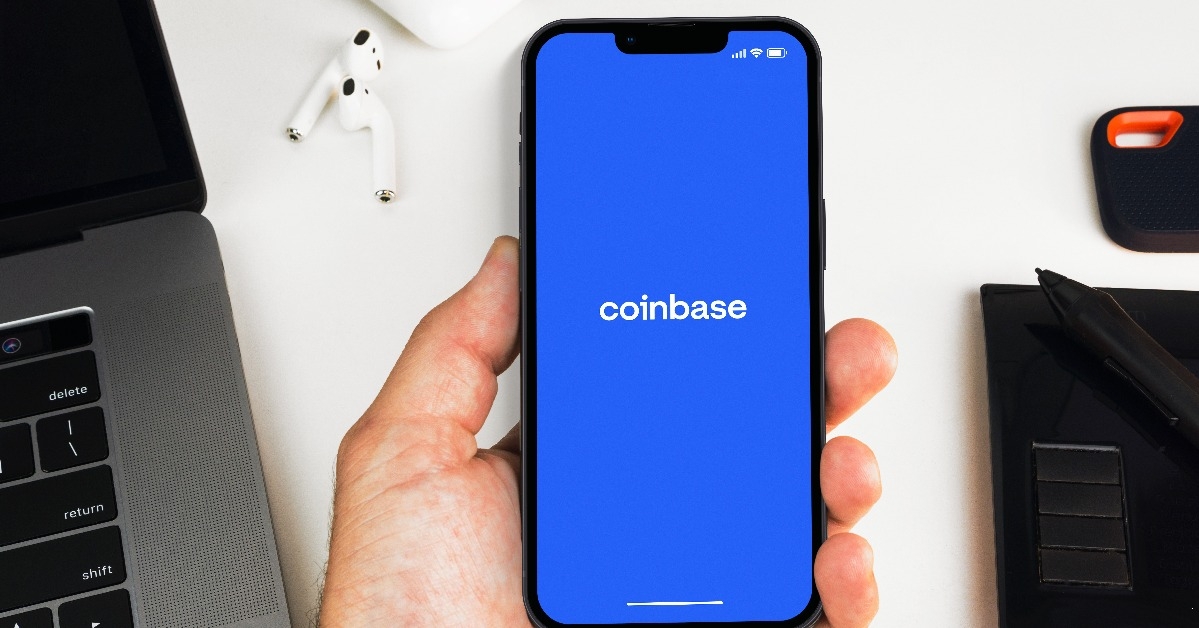 man holding a smartphone with Coinbase exchange app on the screen