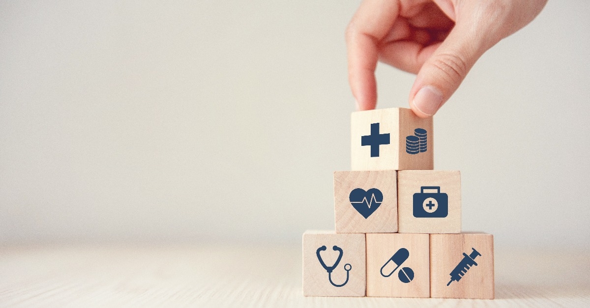 hand arranging wood cube stacking with healthcare medical icon