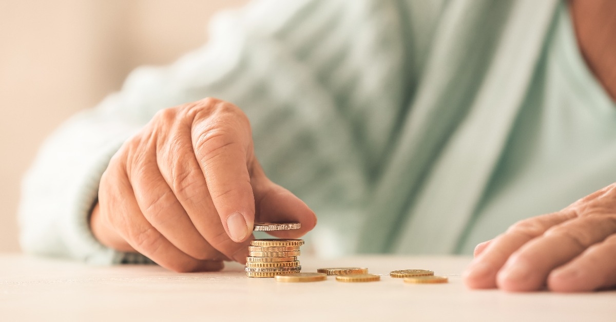 senior woman counting coins on table
