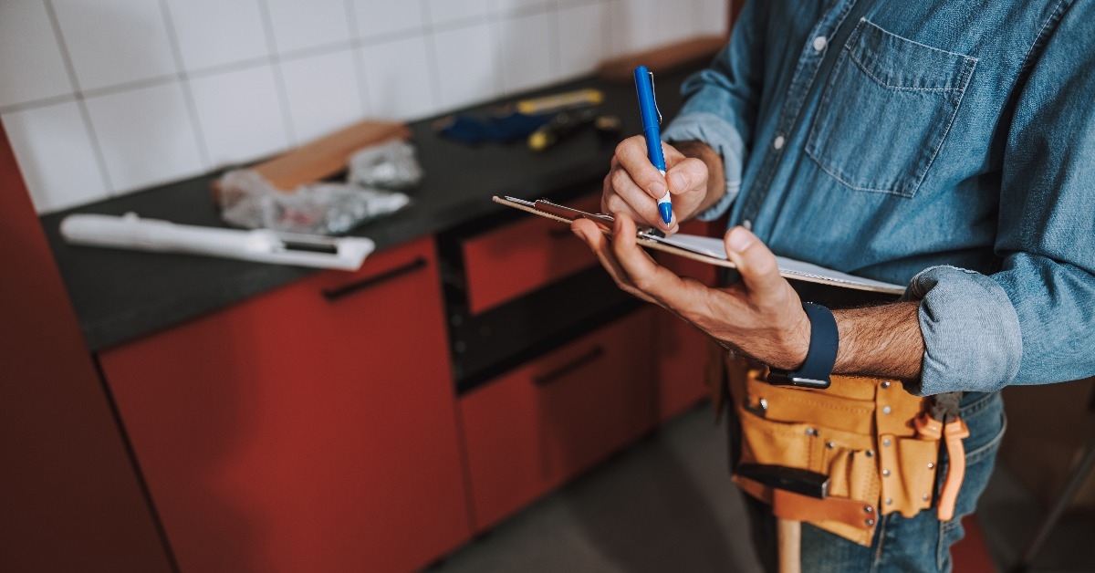 writing on clipboard in the repaired kitchen